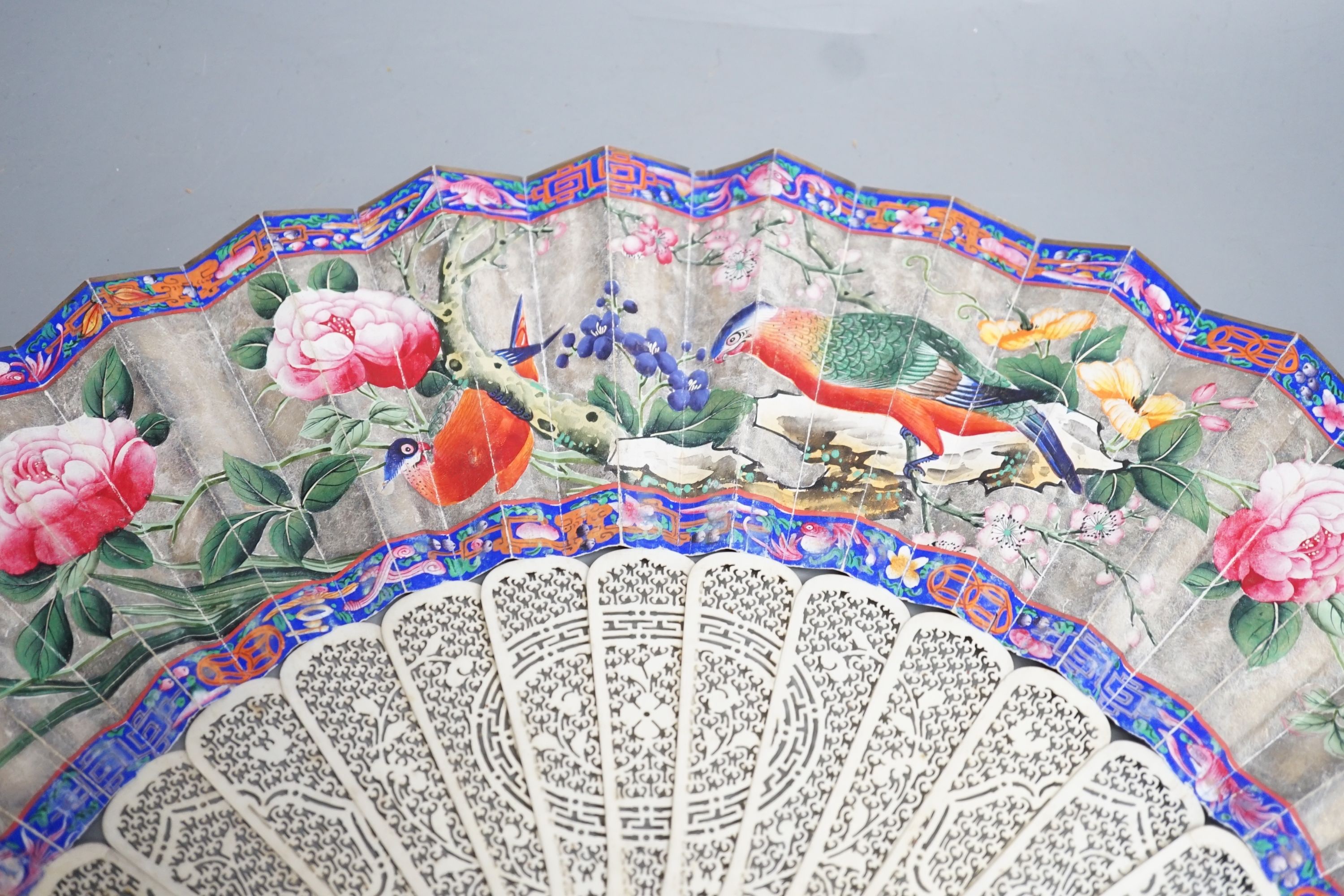 A 19th century Chinese export pierced ivory and painted paper leaf fan. 28cm long